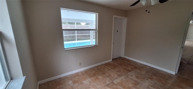 unfurnished room with ceiling fan and baseboards