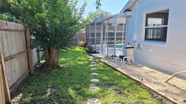 view of yard with glass enclosure, a fenced backyard, and a fenced in pool