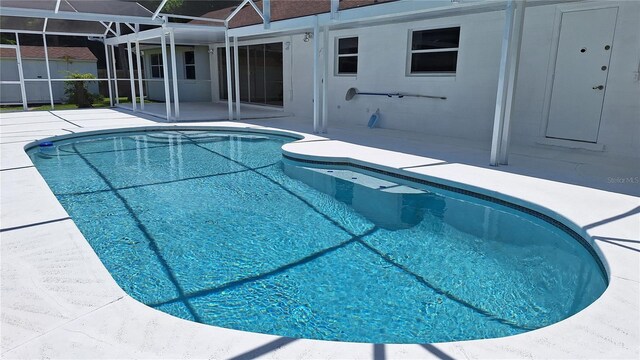 view of swimming pool featuring a patio and a lanai