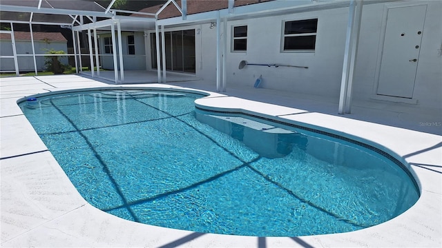 view of swimming pool with glass enclosure, a patio area, and a fenced in pool