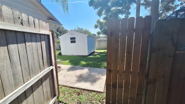 view of yard featuring an outbuilding, fence, and a storage shed