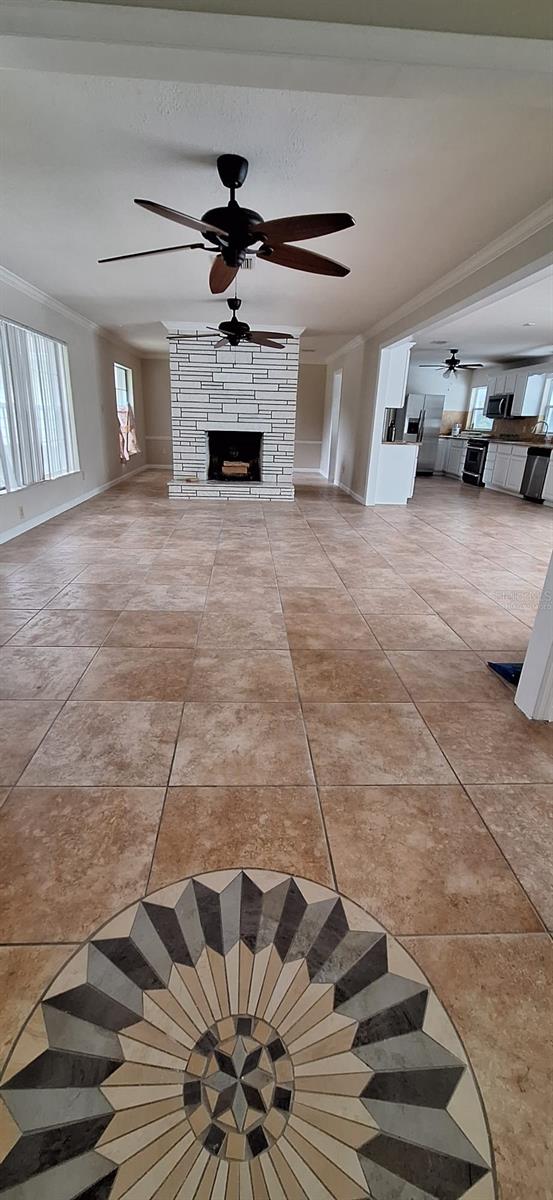 1030 Gregory Dr, Maitland, FL 32751 - staircase featuring ceiling fan, a fireplace, and ornamental molding