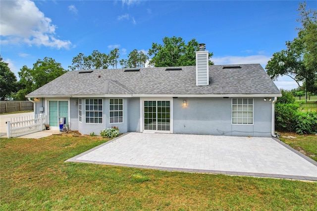 back of house with a lawn and a patio area