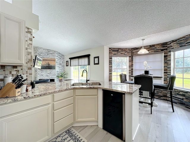 kitchen featuring white cabinets, light stone counters, sink, and tasteful backsplash