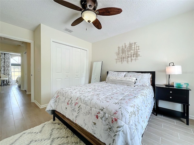 bedroom featuring a textured ceiling, a closet, ceiling fan, and light hardwood / wood-style floors