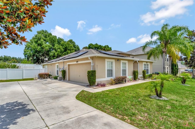 single story home featuring a garage, a front lawn, and solar panels