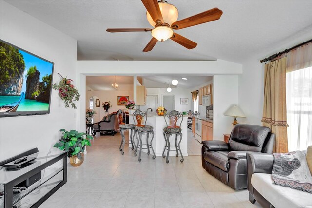 tiled living room featuring lofted ceiling and ceiling fan