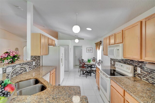 kitchen with vaulted ceiling, white appliances, light tile floors, and tasteful backsplash