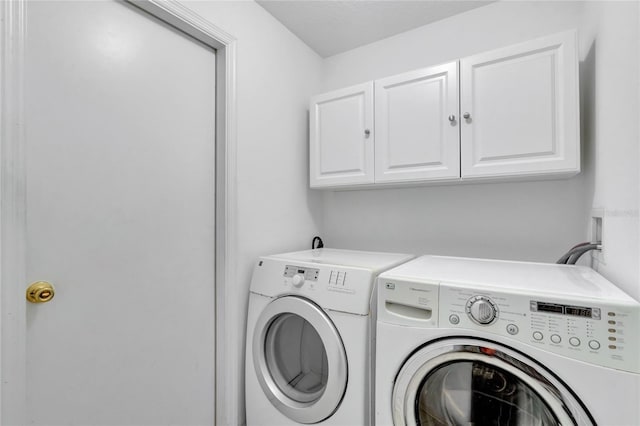 clothes washing area with independent washer and dryer, cabinets, and washer hookup