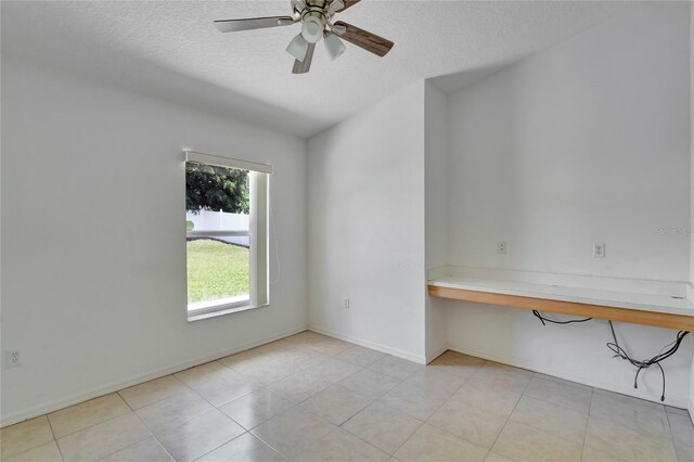 tiled spare room featuring ceiling fan and a textured ceiling