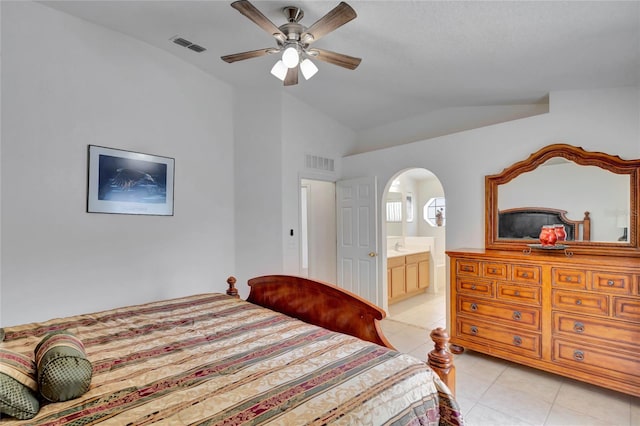 tiled bedroom with lofted ceiling, ceiling fan, and ensuite bath