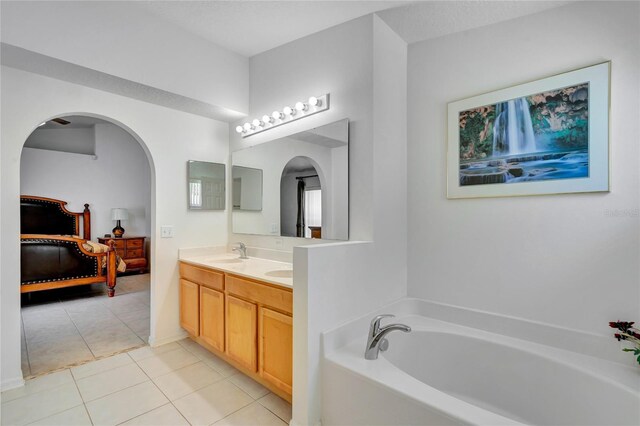 bathroom with double vanity, tile floors, and a bathtub