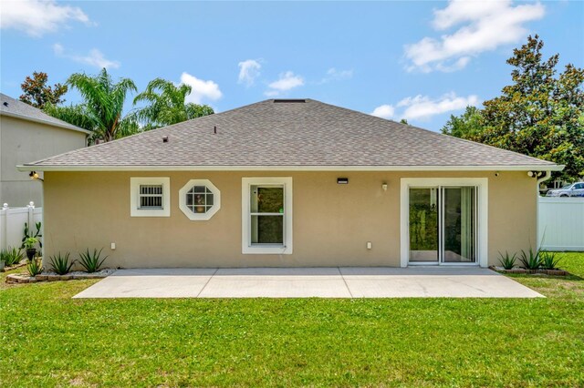 rear view of property featuring a patio and a yard