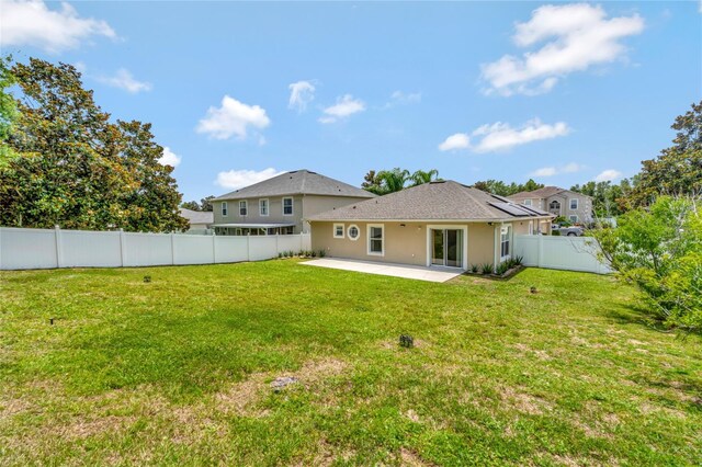 back of property featuring a patio and a lawn