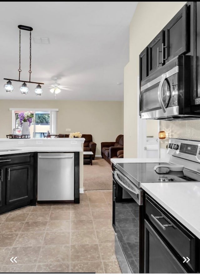 kitchen featuring decorative light fixtures, light colored carpet, stainless steel appliances, sink, and ceiling fan