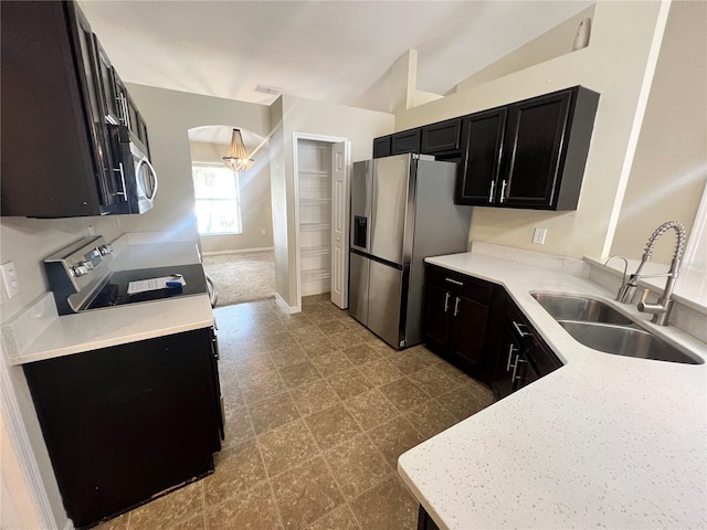 kitchen featuring lofted ceiling, stainless steel appliances, and sink