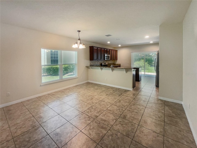 kitchen featuring a kitchen breakfast bar, kitchen peninsula, a wealth of natural light, and appliances with stainless steel finishes