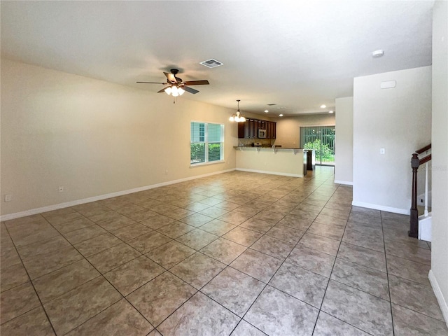 unfurnished living room featuring light tile patterned floors and ceiling fan with notable chandelier