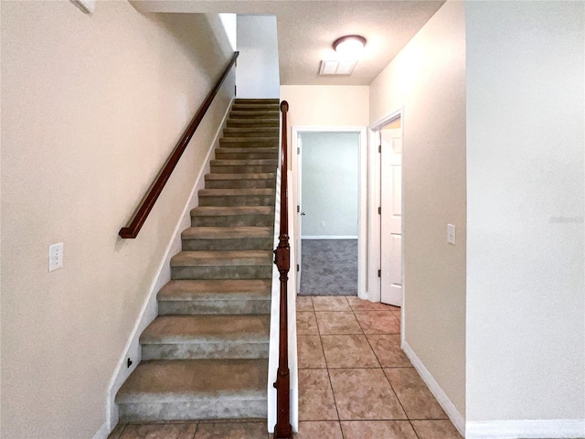 staircase featuring tile patterned floors