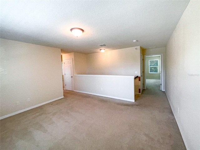 carpeted empty room featuring a textured ceiling