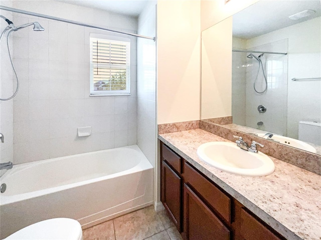 full bathroom with tile patterned floors, vanity, tiled shower / bath combo, and toilet