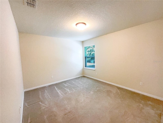 unfurnished room featuring carpet and a textured ceiling