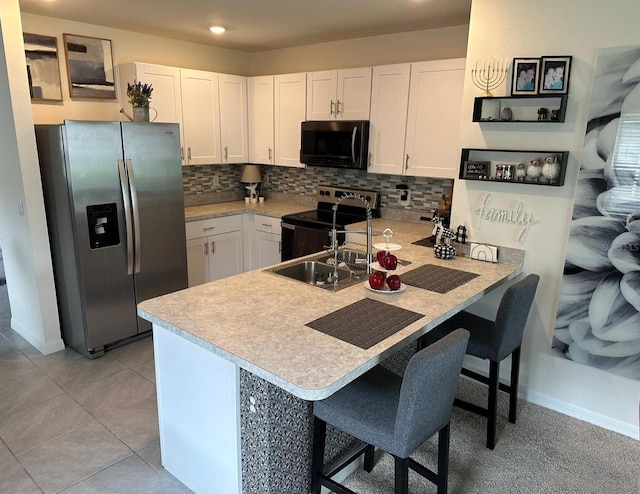 kitchen with appliances with stainless steel finishes, white cabinets, and tasteful backsplash