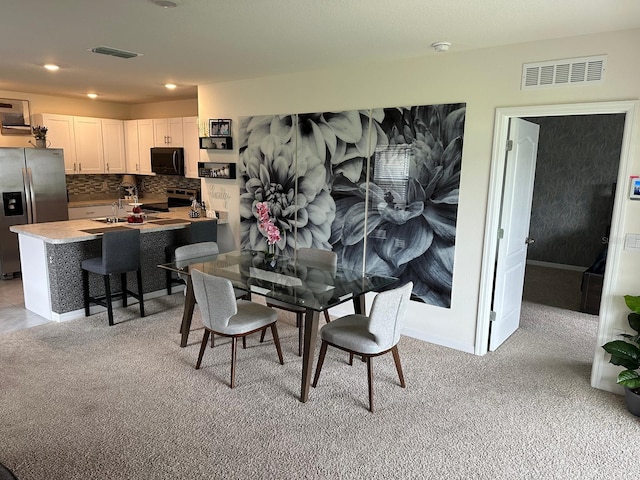 carpeted dining space with sink