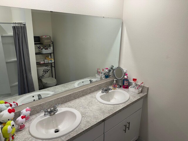 bathroom featuring double sink vanity and toilet