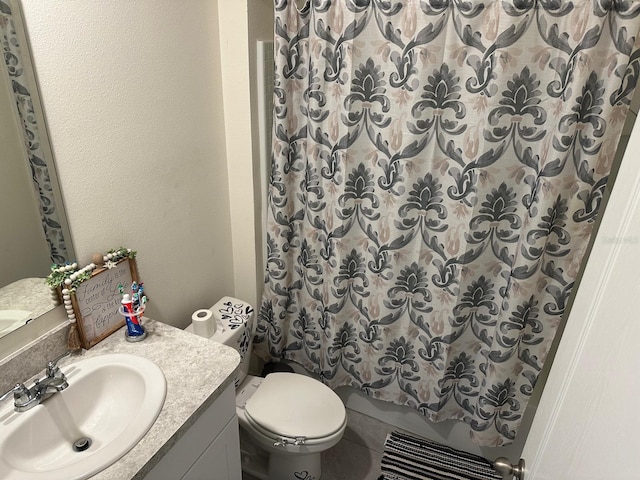 bathroom with tile floors, large vanity, and toilet