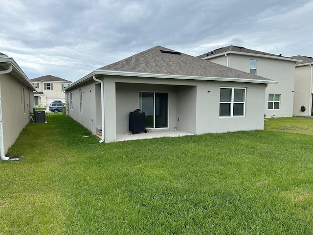 rear view of property with a yard, a patio area, and central air condition unit