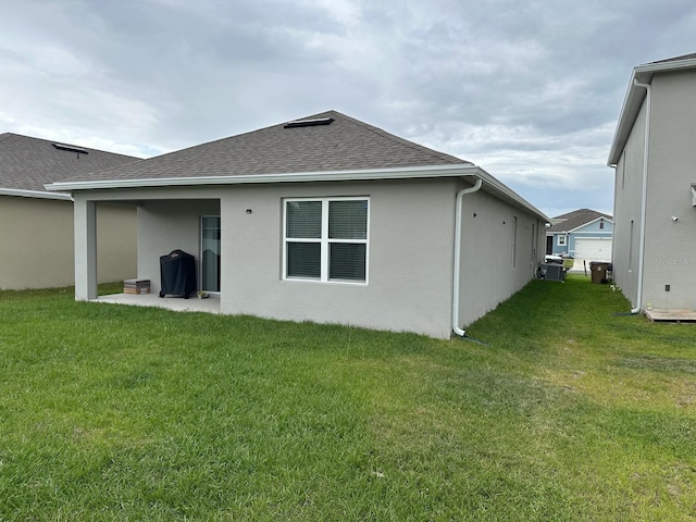 rear view of house featuring a lawn and a patio