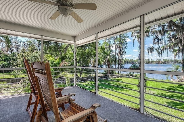 sunroom / solarium featuring ceiling fan and a water view