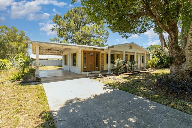 ranch-style house with a carport, covered porch, and a front lawn