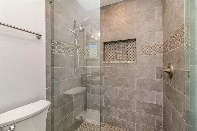 bathroom featuring toilet and an enclosed shower