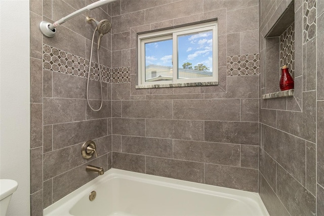 bathroom with tiled shower / bath combo and toilet