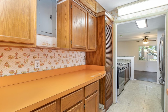 kitchen featuring gas range oven, electric panel, ceiling fan, stainless steel fridge, and light tile patterned floors