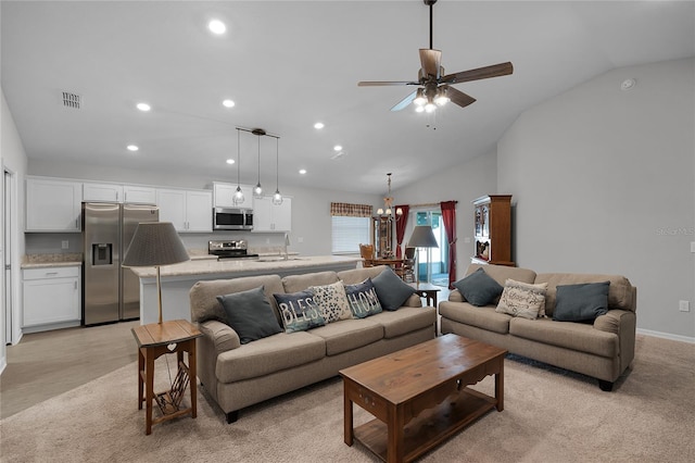 living room with sink, light colored carpet, vaulted ceiling, and ceiling fan with notable chandelier