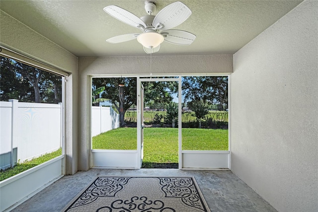 unfurnished sunroom with ceiling fan