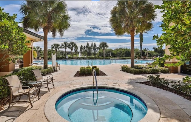 view of pool with a community hot tub and a patio