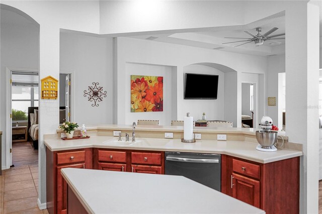 kitchen with stainless steel dishwasher, sink, light tile patterned flooring, and ceiling fan