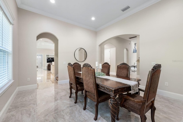 tiled dining space featuring a healthy amount of sunlight and crown molding