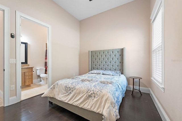 bedroom with ensuite bath and dark wood-type flooring