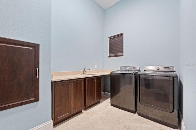 laundry room featuring washing machine and clothes dryer, sink, cabinets, and light tile patterned floors