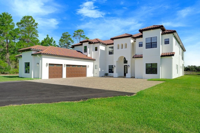 mediterranean / spanish-style home featuring a garage and a front yard