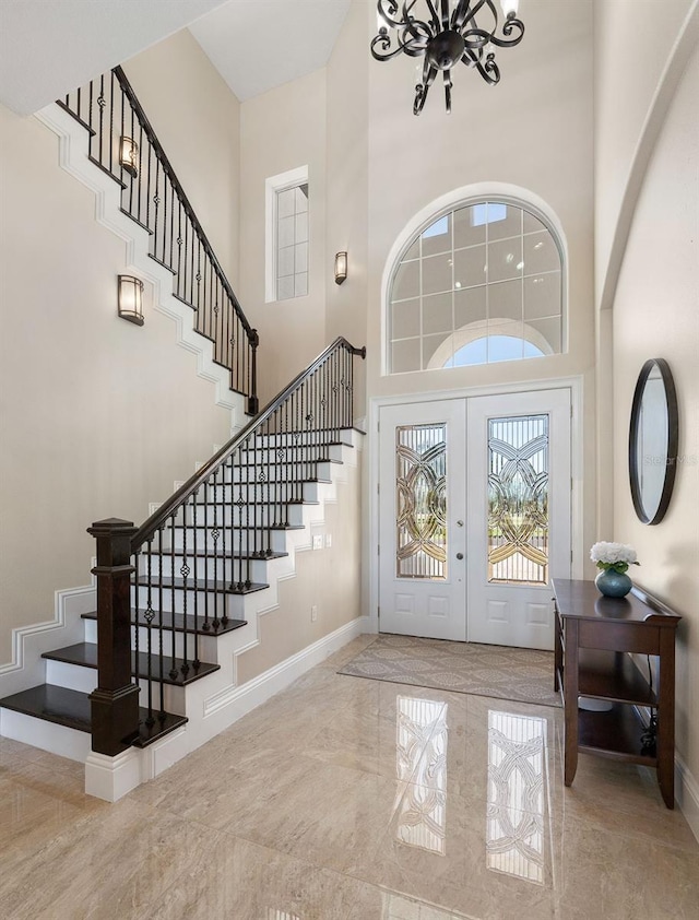 foyer featuring french doors, light tile patterned floors, and a high ceiling