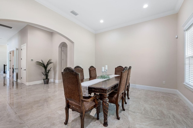 dining room with a wealth of natural light, light tile patterned floors, and crown molding