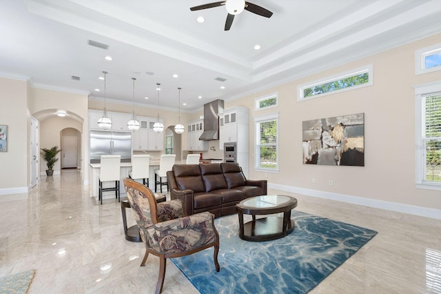 living room featuring light tile patterned flooring, a raised ceiling, crown molding, and ceiling fan