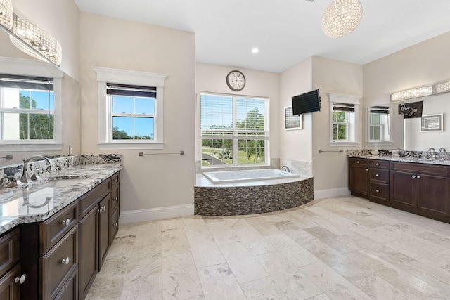 bathroom featuring tiled bath, tile patterned floors, and vanity