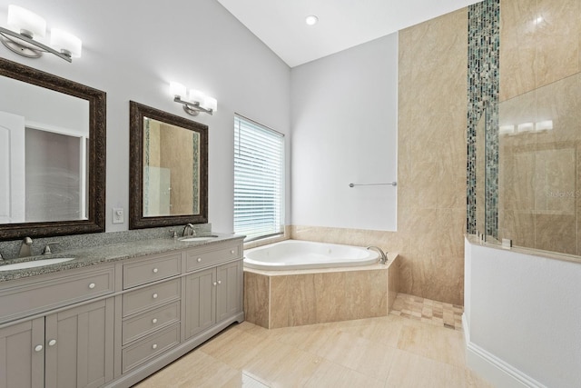 bathroom with tiled tub, dual vanity, and tile patterned floors